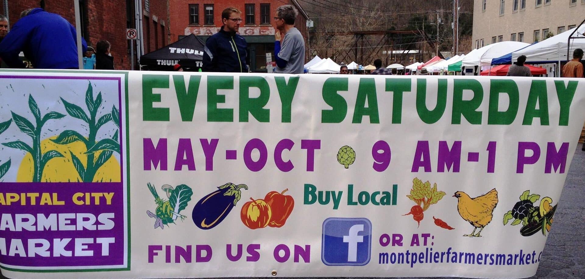 large banner sign at Farmers markets in Northern Vermont|dunc mill rum on a floral top table