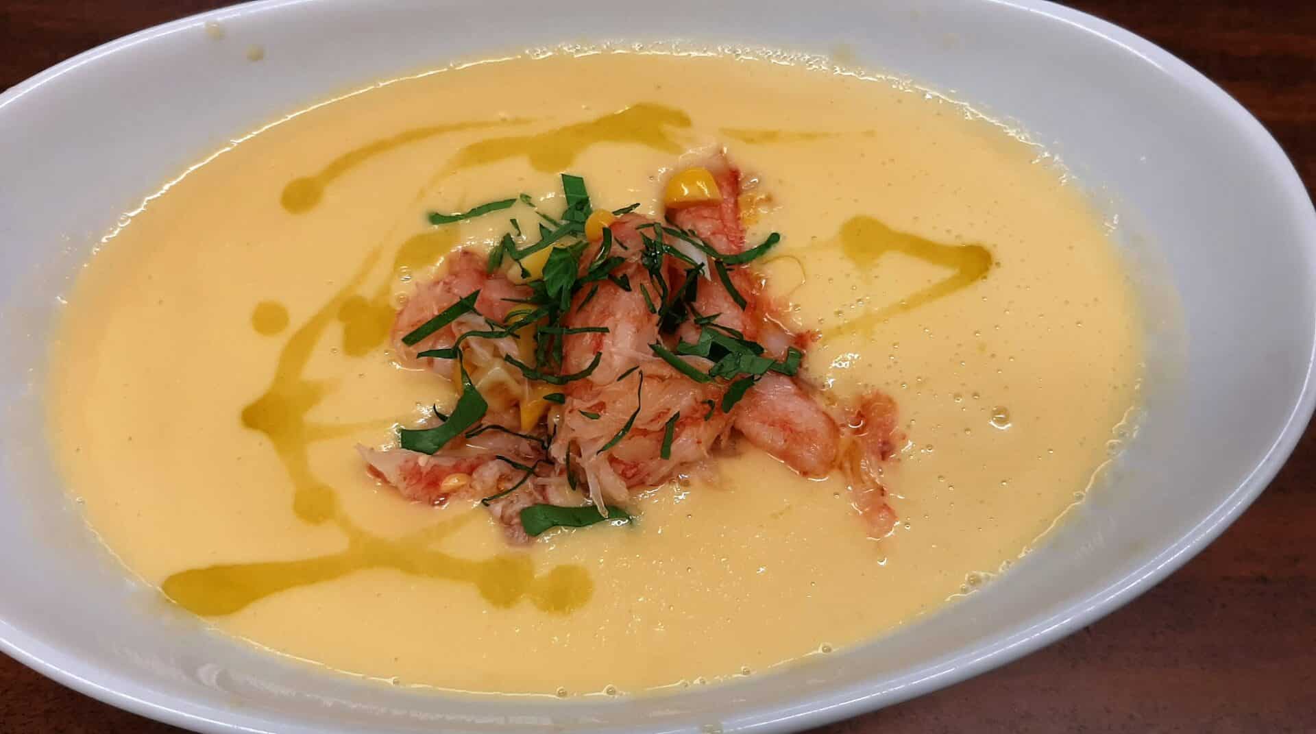 A bowl of corn soup topped with fresh crab meat