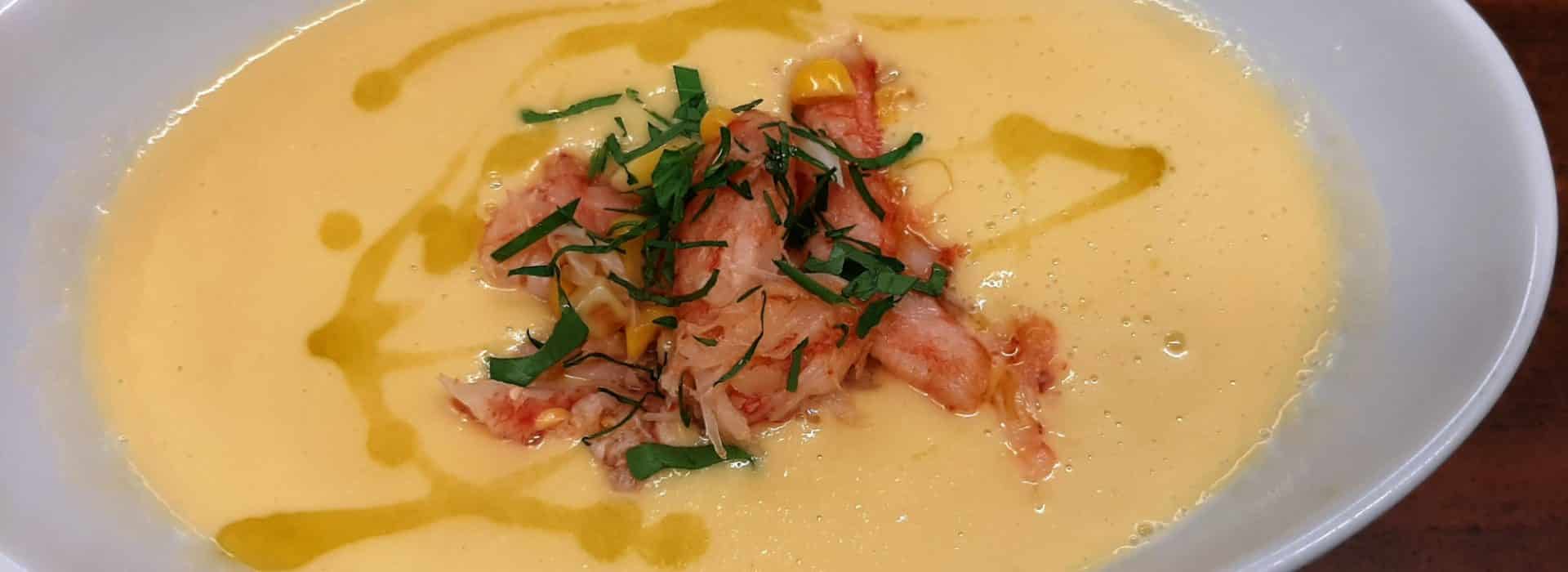 A bowl of corn soup topped with fresh crab meat