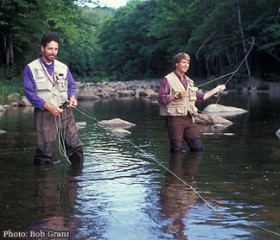 two men standing in the water casting fly fishing rods