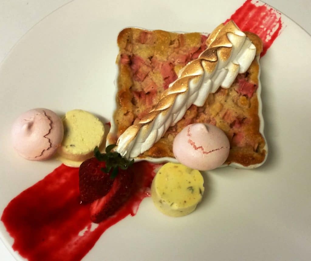 Rhubarb custard dessert served with saffron-cardamom-pistachio kulfi , rose meringue , and raspberry coulis 