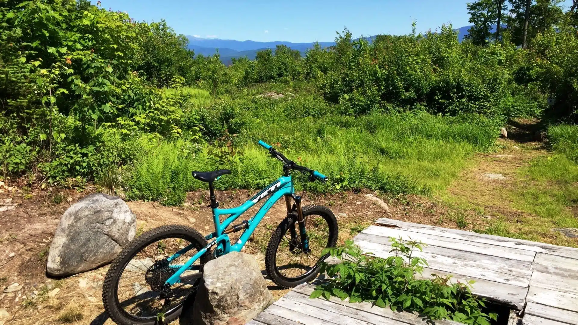 bike on a hiking trail|road leading to the PRKR MTN trailhead Littleton New Hampshire|parked bicycle on the Parker Trails PRKR Mountain trails in Littleton New Hampshire|trail sign in the woods at Parker Trails