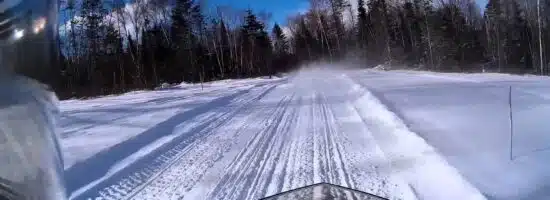 Vermont snowmobile trails as seen from the seat of a snowmobile|couple on a snowmobile tour|couple on a snowmobile|couple on a snowmobile