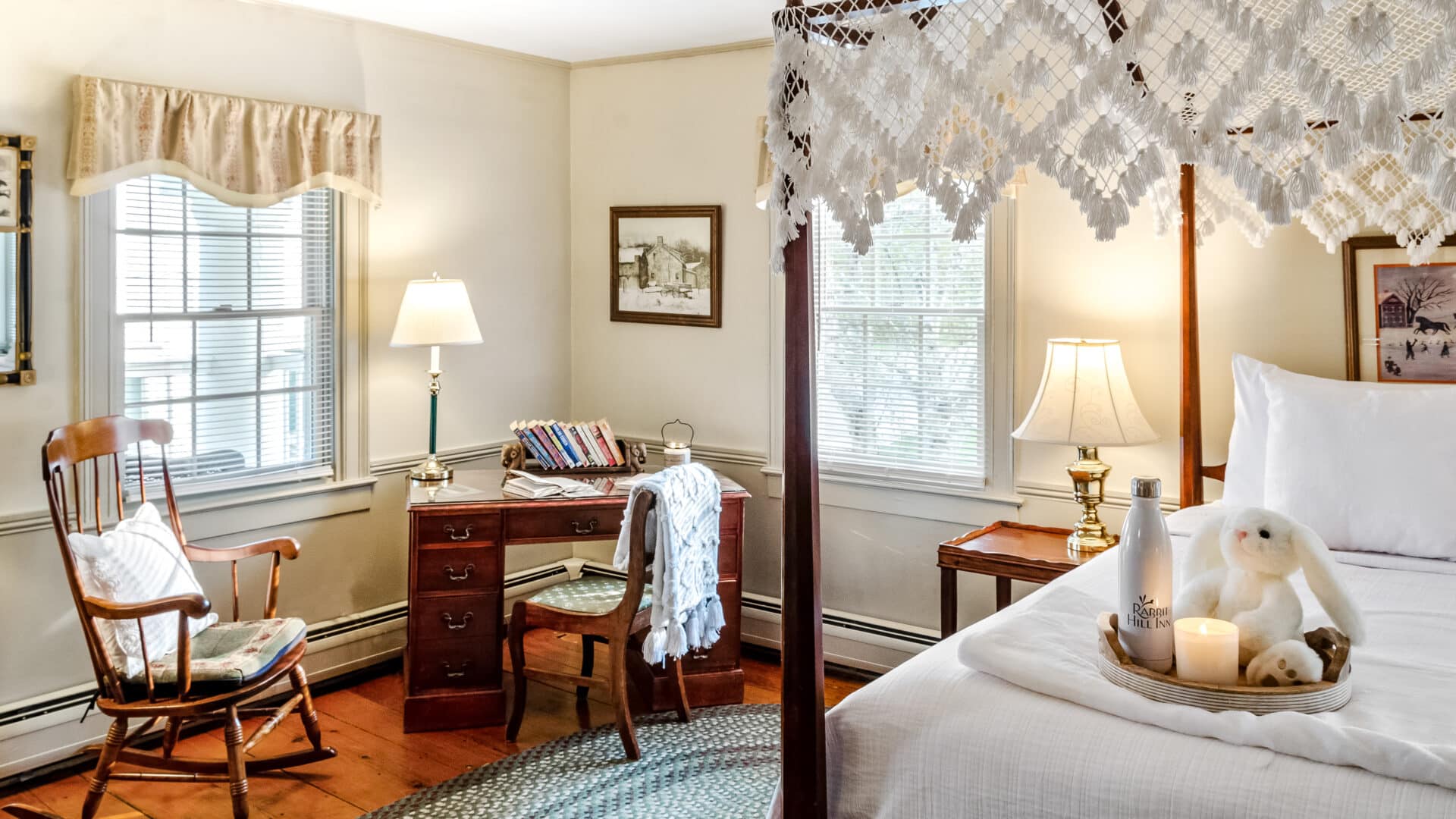 Charming vintage-style guest room with canopy bed and writing desk at a New England Bed and Breakfast