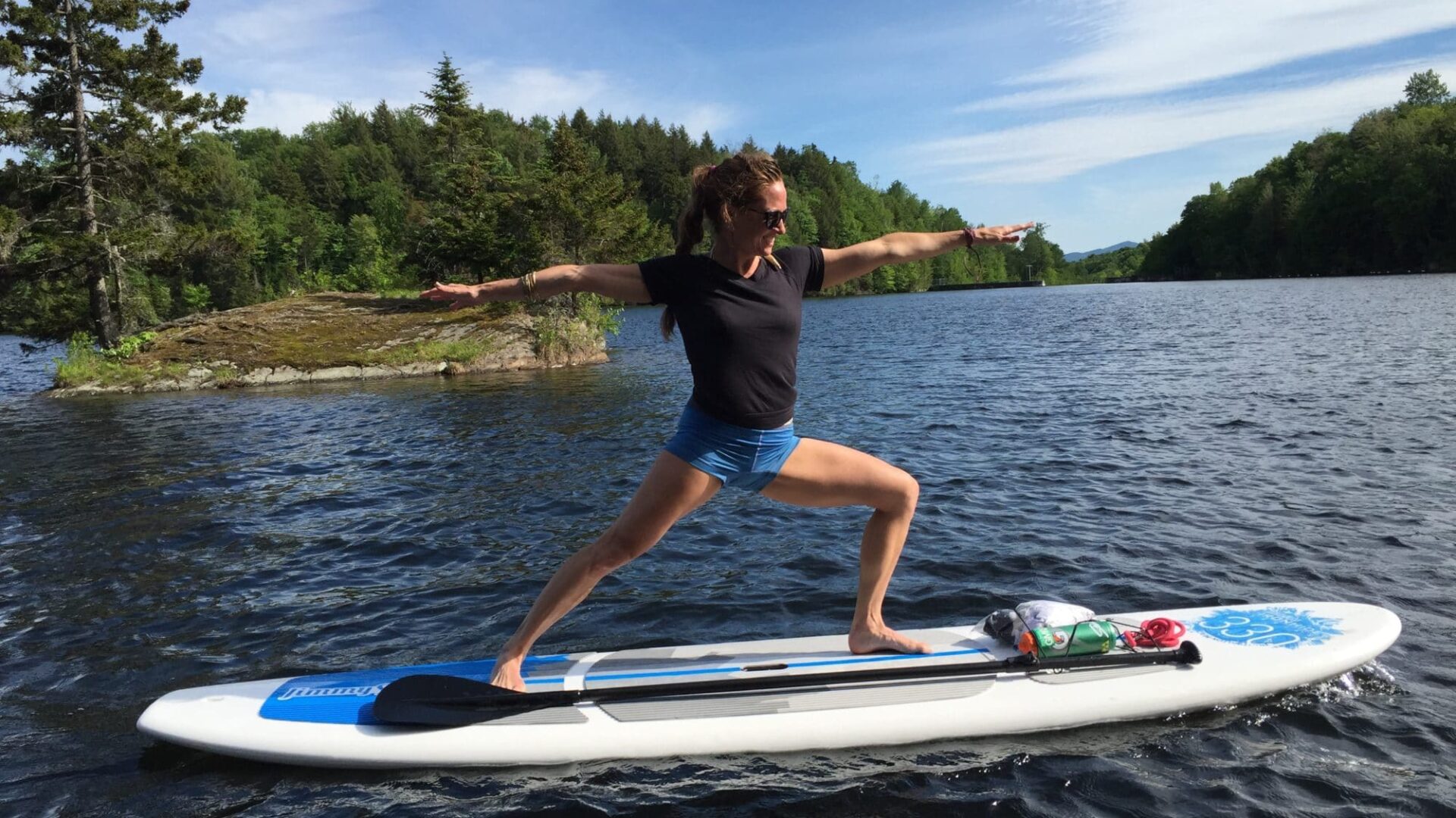 woman standing on a paddle board on the the water