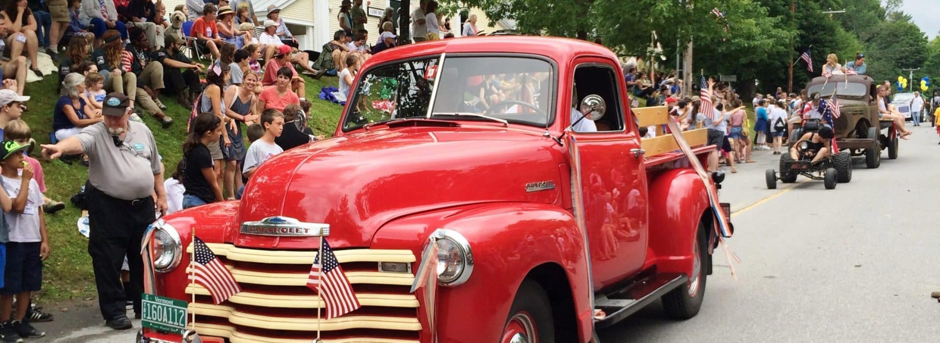 red truck in the parade at the Stowe Antique Car Show and Antique Car Parade|several people at the Stowe Vermont Antique Car Show