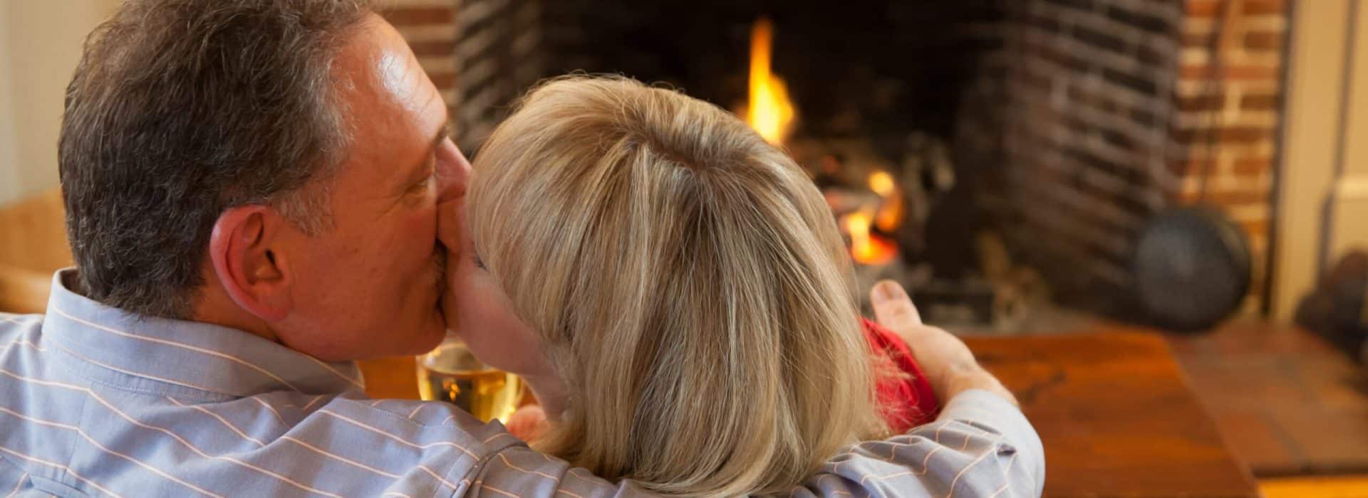 couple kissing in front of a fireplace|Best Romantic Vermont Weekend Getaways