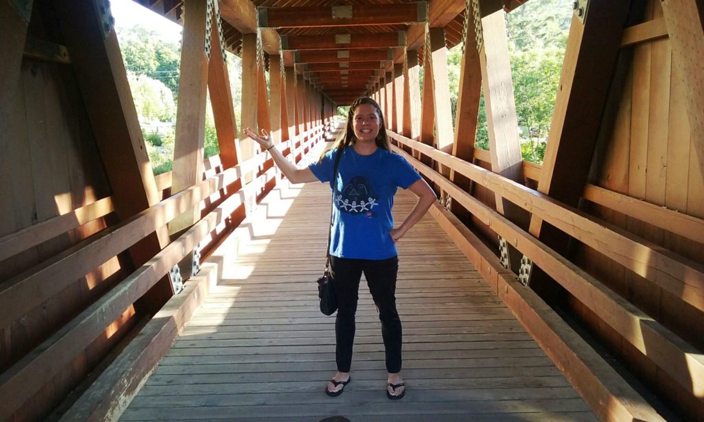 girl standing on a covered bridge