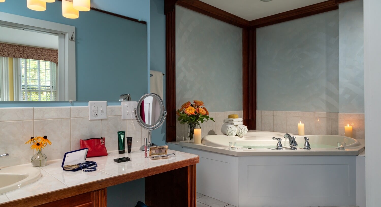 blue bathroom with wood trim, spa tub, and vanity