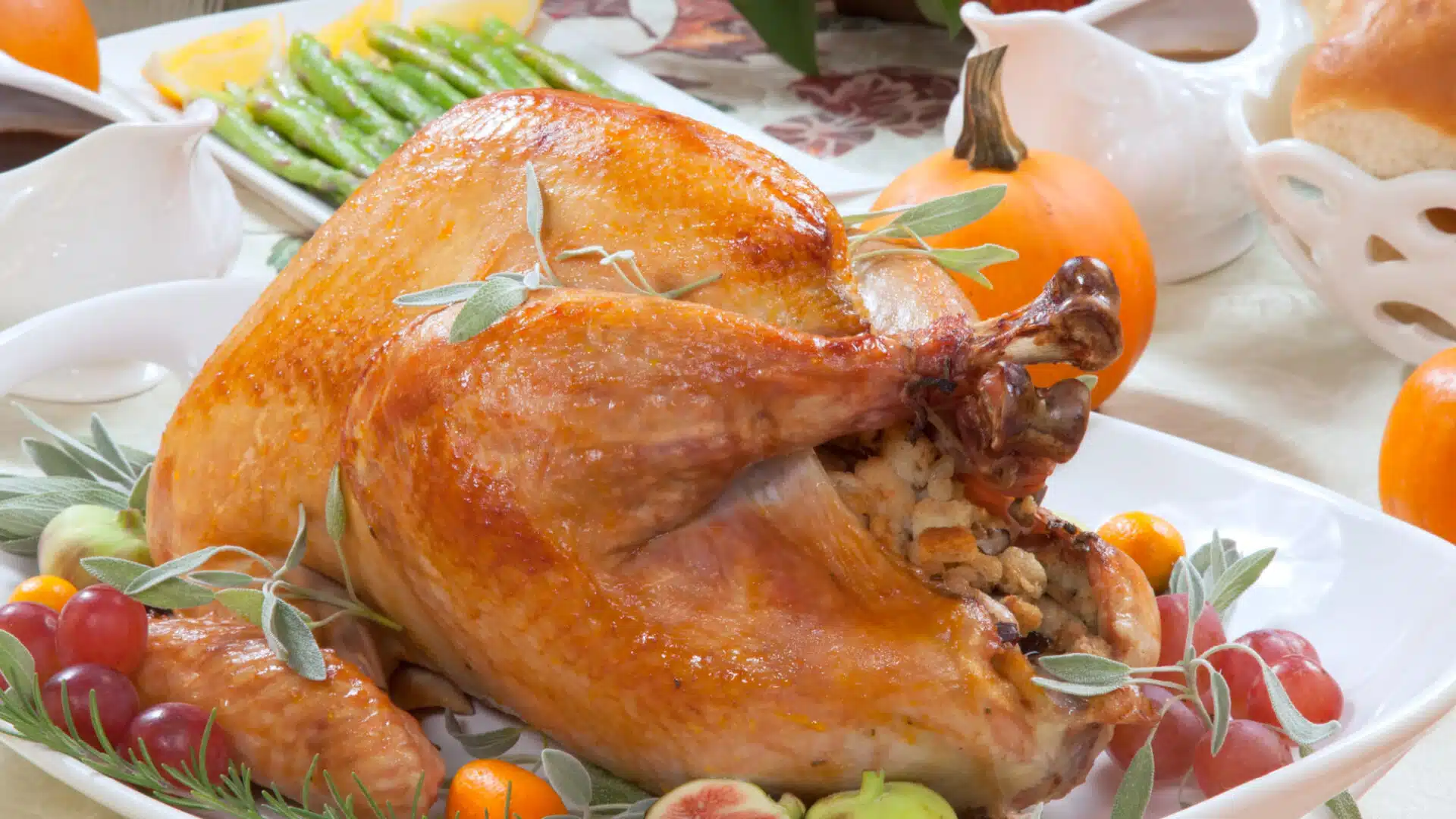 Roasted turkey on platter at Thanksgiving table