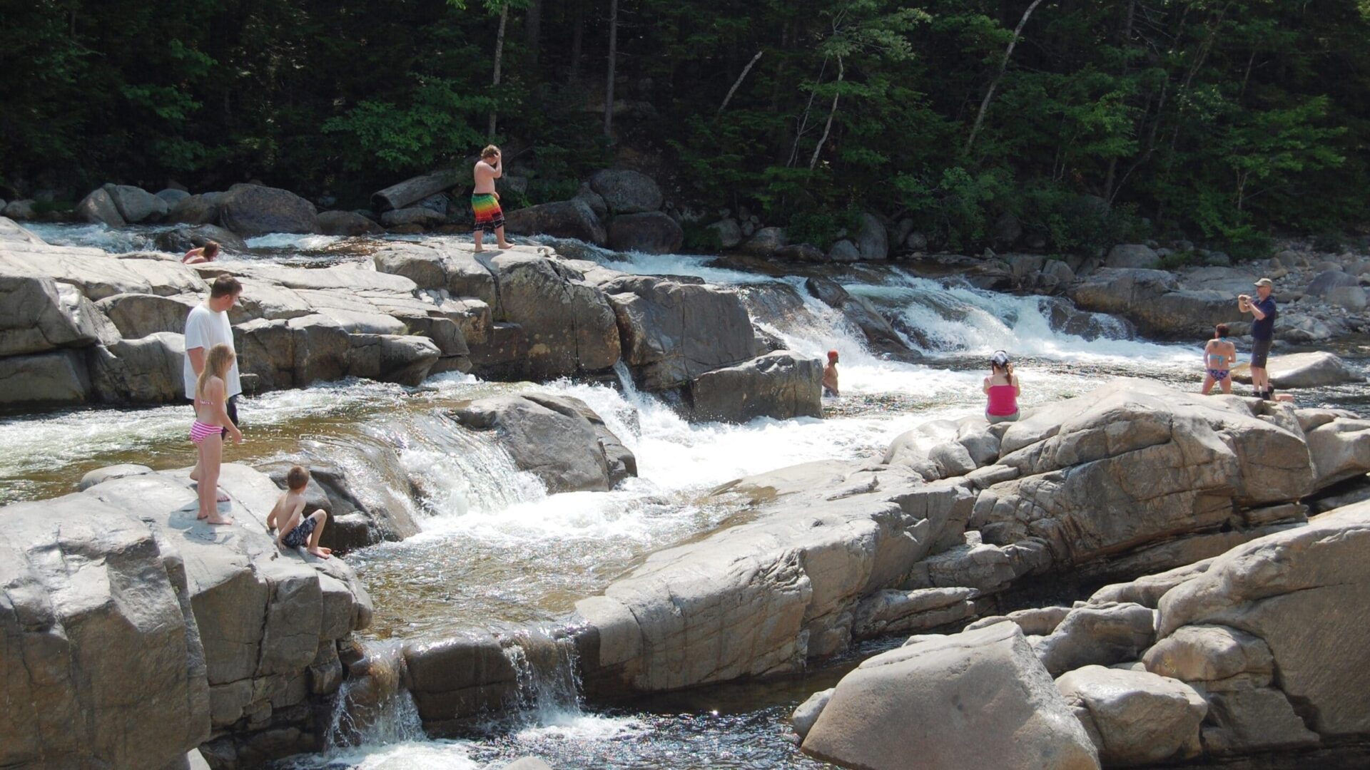 people on the rocks at a Swimming Holes in the White Mountains New Hampshire