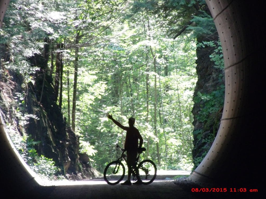 man standing next to bike on the Lamoille Valley Rail Trail 