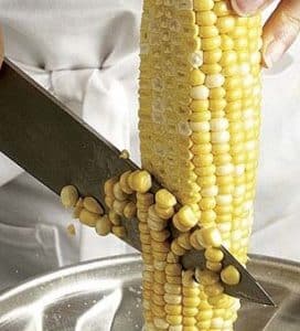 knife cutting corn kernels off the cob