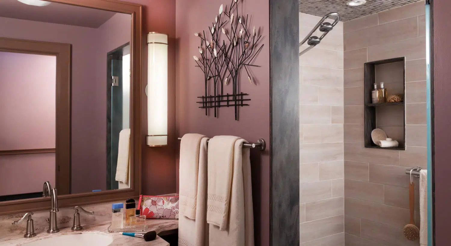 Bathroom with light lavendar walls, marble sink, light tan tiled stand up shower, and large wooden framed mirror
