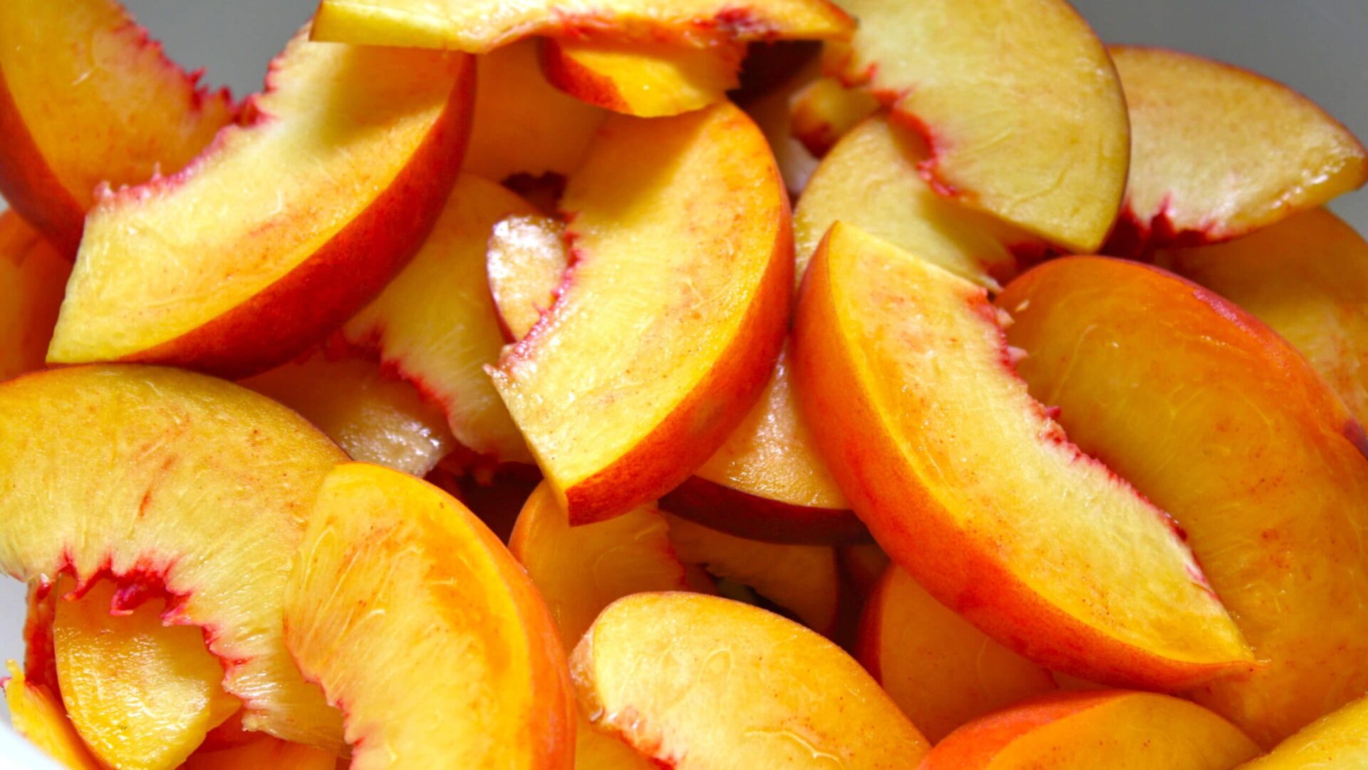 sliced peaches for peach BBQ sauce recipe.|fresh peaches|bowl of fresh peaches
