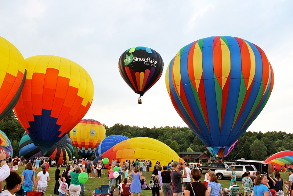 several hot air balloons lifting off the ground at the stowe Vermont hot air balloon festival