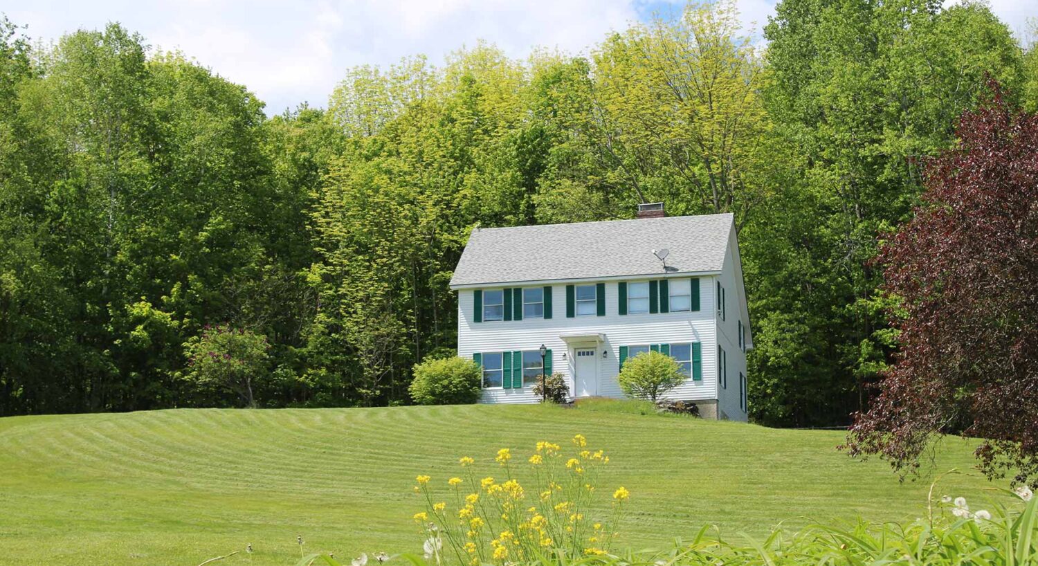 Charming countryside house with green shutters and open lawn at one of the top hotels near St Johnsbury VT