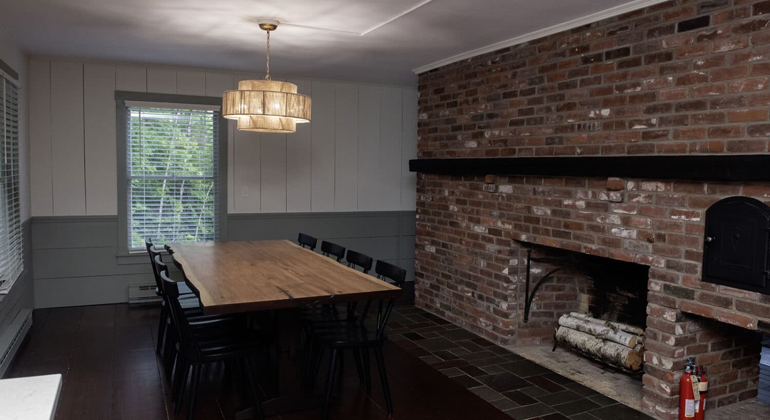 Rustic dining room with brick fireplace and long wooden table at one of the welcoming hotels near St Johnsbury VT